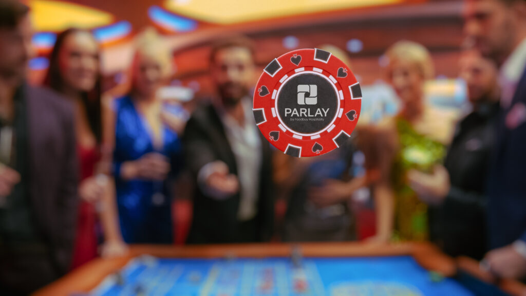 Multiethnic Young Adults Playing an Engaging Game of Roulette, Spending a Fun Evening in a Luxurious Hotel Casino. Enthusiastic Gambler Tossing a Red Casino Chip with Template Placeholder